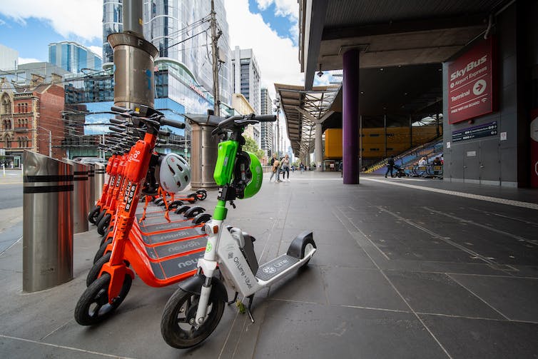 bank of e-scooters on city footpath