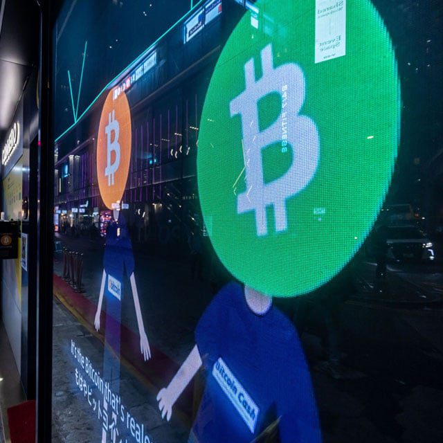 Bitcoin logos on a screen in Hong Kong, China