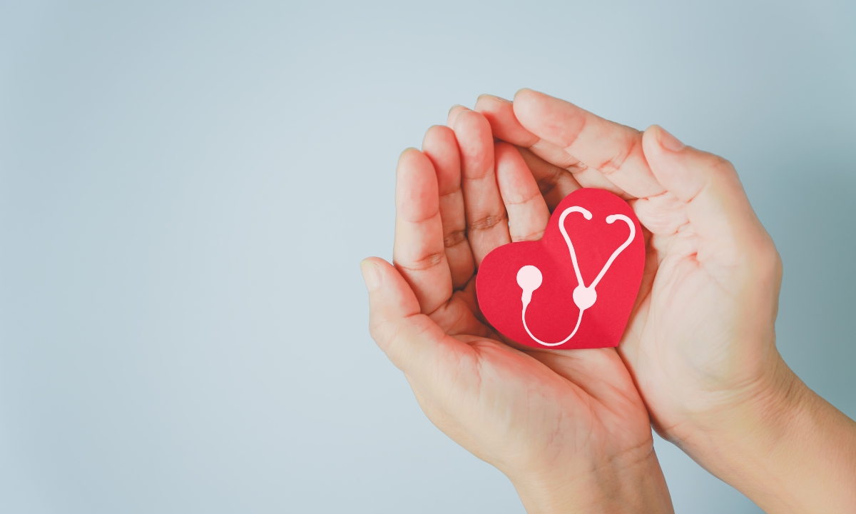 Health Insurance sign on a heart held by a man