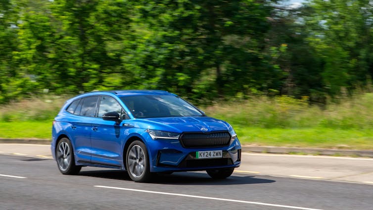 blue electric car driving on British country road