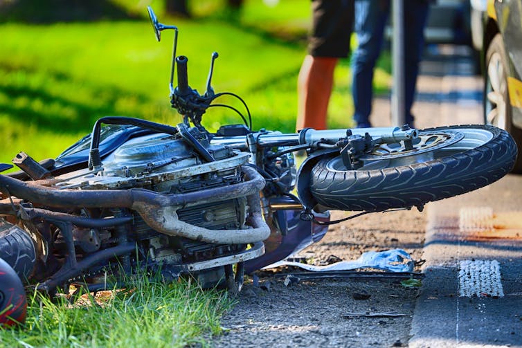A crashed motorcycle on the side of the road.