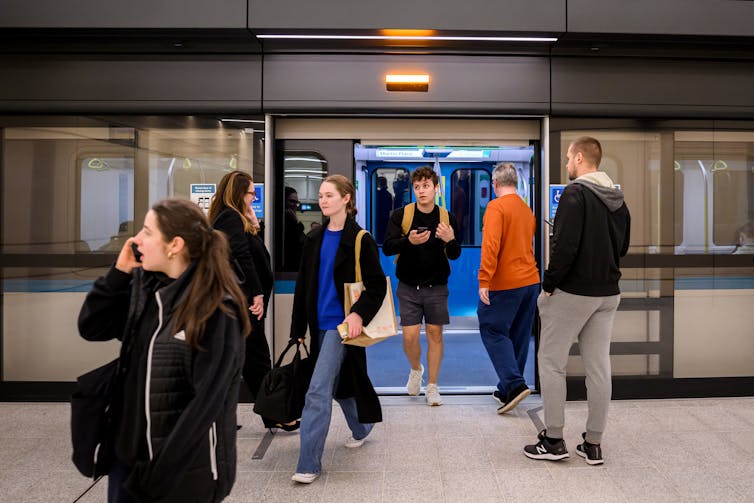 Commuters disembark the train at Martin Place Metro Station, in Sydney