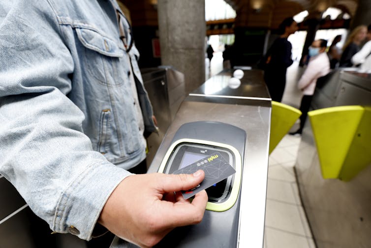 Commuter touches on their Myki at a turnstyle